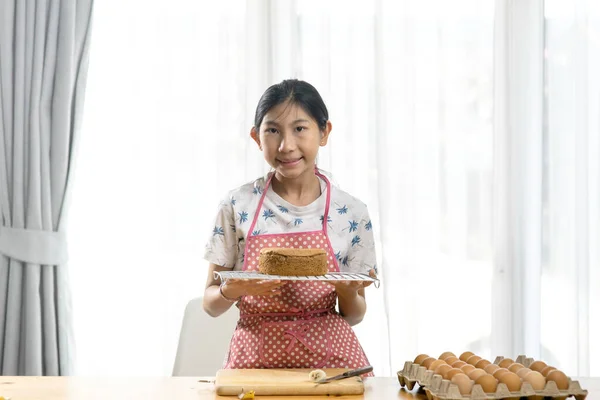 快乐的亚洲女孩在家里展示自制的海绵蛋糕 生活方式 待在家里的观念 动作模糊 — 图库照片