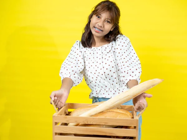 Mutlu Asyalı Genç Kız Elinde Ekmek Ekmeği Ile Sarı Arka — Stok fotoğraf