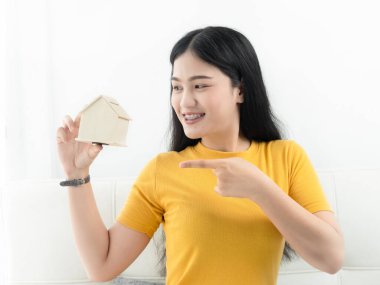 Evi elinde tutan Asyalı kadın emlak kavramı.