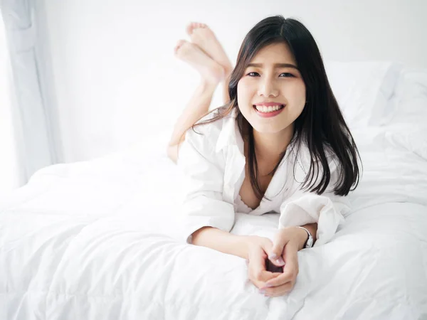 快乐的亚洲女人躺在床上休息 生活方式的概念 — 图库照片
