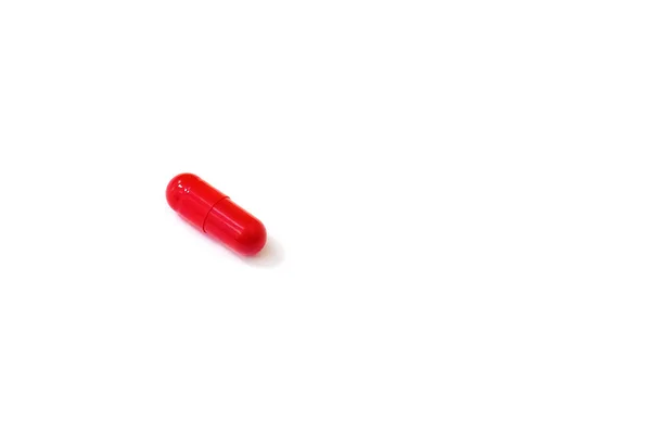 Pilule rouge sur fond blanc gros plan . — Photo