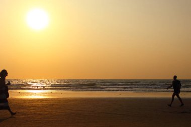 sahilde gün batımında insanlar gitmek
