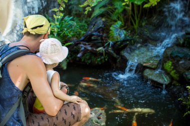 Bir adam bir balık pond izlerken onun kızı ile