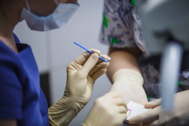 Tedavi ve protez sürecinde lastik eldivenlerin içindeki dişçi elleri. Diş aletleriyle doktor eli..