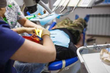 Diş hekiminin muayenehanesindeki hastanın tedavisi. Protez işlemi ve diş aletleri ile hastanın ağzı.