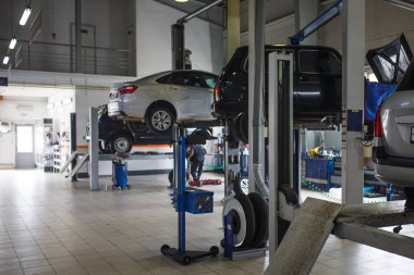 Araba servis istasyonunun genel planı. Servis merkezinin arkaplan görüntüsü olan bulanık arabalarla iletiler ve asansörler.