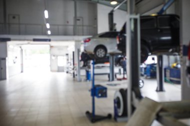 Araba servis istasyonunun genel planı. Servis merkezinin arkaplan görüntüsü olan bulanık arabalarla iletiler ve asansörler.