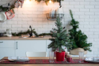 Evin mutfağının Noel süslemesi çatı katı tarzında. Köknar dalları ve çelenklerle süslemeler
