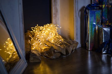 Evde Noel süslemelerinin unsurları. Noel ışıkları çelenkler, tahta oyuncaklar, ağacın altındaki hediyeler.