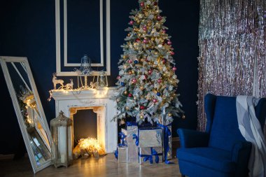 Evin yeni yılı için dekore edilmişti. Noel ağacı ve dekore edilmiş stüdyo, ışık çelenkleri, süslemeler, rahat bir evde hediye kutuları, büyük bir koltuk ve şömine..