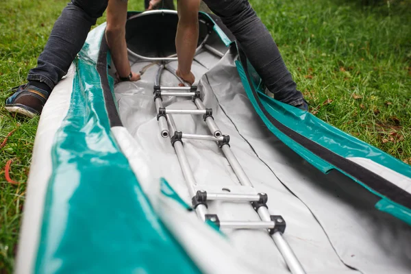 The process of assembling and repairing kayaks: metal skeleton, PVC skin, wooden and aluminum frames. Male hands assemble the canoes and paddle boating. — Stock Image Process Assembling Repairing Kayaks Metal Skeleton Pvc Skin Wooden Aluminum Royalty Free Stock Images