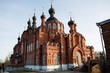 Kaluga Bakiresi 'nin manastırı. Güneşin parlak ışığında. Shamordino 'daki manastırın yüksek duvarlarını kırmızı tuğla oymuş.