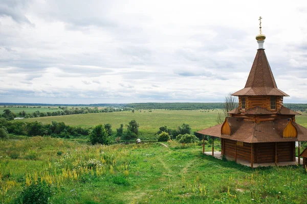 パノラマの景色を望む高い丘の上に本物のロシアの木造教会の建物 高い丘の上にキリスト教フォント — ストック写真