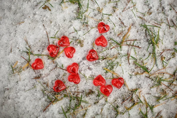 红色的玻璃心散落在雪地上 情人节的象征 背景是雪白的质感和心灵 — 图库照片