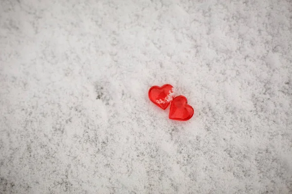 雪地上有两颗红色的玻璃心 情人节的象征 背景是雪白的质感和心灵 — 图库照片