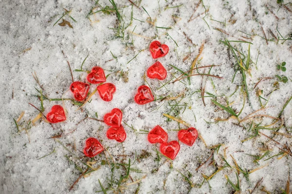 红色的玻璃心散落在雪地上 情人节的象征 背景是雪白的质感和心灵 — 图库照片