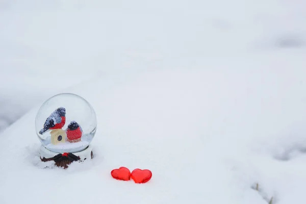 Karlı Cam Bir Topta Iki Ispinoz Karda Kırmızı Cam Kalpler — Stok fotoğraf