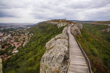 Bulgaristan 'daki antik bir savunma yapısı-Ovech kalesinin taş duvarındaki tahta köprü. Uçurumun tepesindeki ahşap yolun eski kalasları
