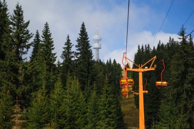 Yaz mevsiminde Bulgaristan 'ın kayak alanında teleferik. Sarı iskemle kayak asansörü, Rodop dağlarındaki yeşil köknar ve çam ağaçları arasındadır.