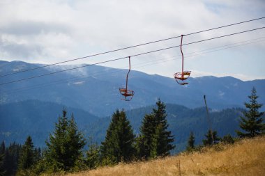 Yaz mevsiminde Bulgaristan 'ın kayak alanında teleferik. Sarı iskemle kayak asansörü, Rodop dağlarındaki yeşil köknar ve çam ağaçları arasındadır.