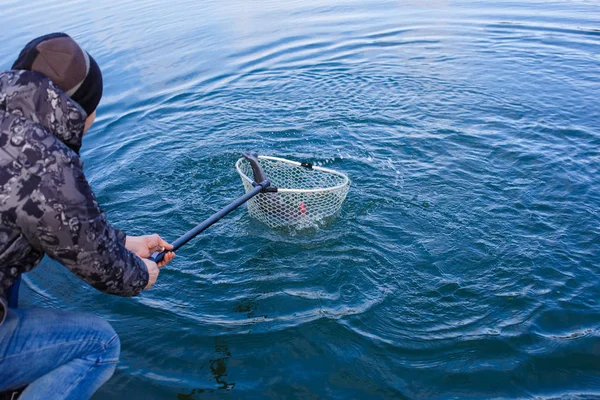 Der Fischer Fängt Den Fisch Mit Einem Netz Aus Dem — Stockfoto