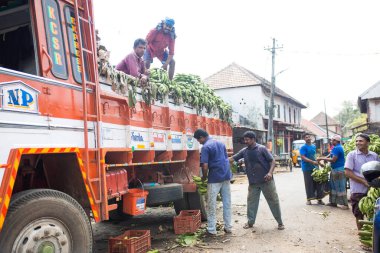 Kerala, Hindistan-29 Ocak 2019. Tipik bir Hint pazarı - muz yüklü bir araba, malları boşaltan adamlar