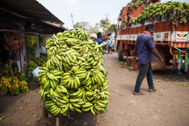 Kerala, Hindistan-29 Ocak 2019. Tipik bir Hint pazarı - muz yüklü bir araba, malları boşaltan adamlar