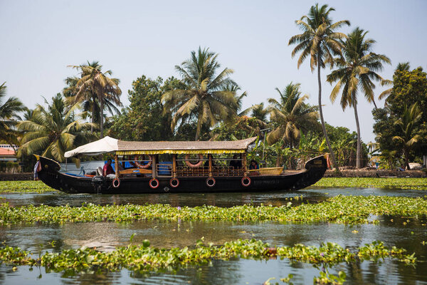 Kerala, India-February 4, 2019. A traditional tourist attraction is the house-boat on the river channels of Kerala in Alapuja, overgrown with algae