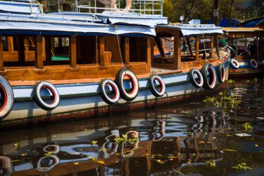 Renkli eski araba lastikleri bir zevk teknesinin yanında asılı duruyor. Geminin yan taraflarını parlak güneşte kullanılmış lastiklerden ve suda yansımalardan korumak için harika bir koruma.