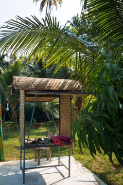 Yoga minderli tropikal palmiyeler arasında hasır taraça. Hindistan 'da yoga için bir yer, Kerala..