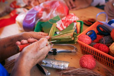 Evde, masada oturan çocuklar için yaratıcı eşyalar ve el sanatları. Boyalar ve fırçalar, makas, iplik ve kumaş kırıntıları - arka planda çocuğun ve ebeveynin elleri.