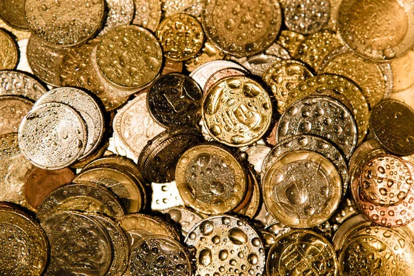 Altın ışıkta ve suda farklı ülkelerin sikkeleri. Para birimi 1 Euro yakın plan ve diğer ulusal para birimleri.