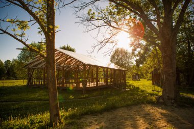 Olaylar ve ziyafetler için parktaki ahşap çardak. Güneş ışığı, ahşap kirişlerin arasından geçiyor. Chiaroscuro oyunu. Metin ve arkaplan yeri