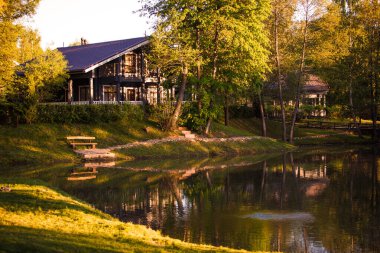 Golitsyno, Kaluga, Rusya-18 Mayıs 2019. Gri ahşap yazlık ev, eko-parktaki pitoresk bir gölde. Bahar-Yaz