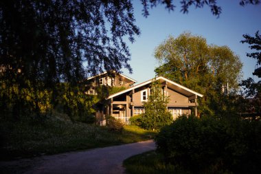 Golitsyno, Kaluga, Rusya-18 Mayıs 2019. Resimli bir orman eko-parkındaki gri ahşap yazlık evde. Kırsaldaki bir kır evine giden rahat bir yol. Bahar-Yaz