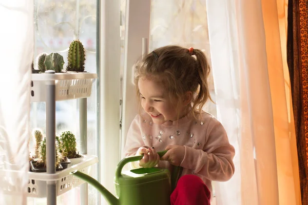 Una Niña Con Una Regadera Verde Está Jugando Ventana Casa —  Fotos de Stock