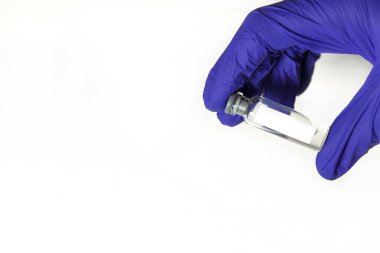Doktorun elleri mavi tıbbi kauçuk eldivenler içinde mesaj için yer olan bir şişe tutuyor. Tıbbi konsept, salgının tedavisini içeren şişe. Beyaz arkaplan