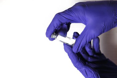 Doktorun elleri mavi tıbbi kauçuk eldivenler içinde mesaj için yer olan bir şişe tutuyor. Tıbbi konsept, salgının tedavisini içeren şişe. Beyaz arkaplan