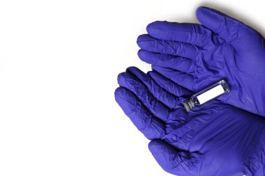 Doktorun elleri mavi tıbbi kauçuk eldivenler içinde mesaj için yer olan bir şişe tutuyor. Tıbbi konsept, salgının tedavisini içeren şişe. Beyaz arkaplan