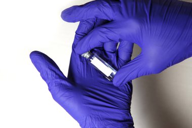 Doktorun elleri mavi tıbbi kauçuk eldivenler içinde mesaj için yer olan bir şişe tutuyor. Tıbbi konsept, salgının tedavisini içeren şişe. Beyaz arkaplan