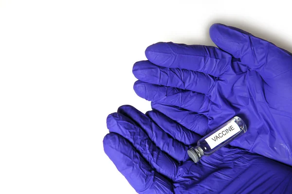 医生戴着蓝色医用橡胶手套的手拿着一个印有 Vaccine 字样的小瓶 医学概念 用药瓶来治疗这种流行病 白人背景 — 图库照片