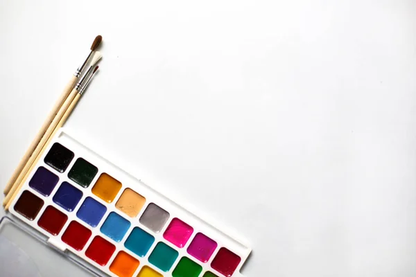 テキストのためのスペースを持つ白い背景に18色の水彩と絵筆のパレット 子供の創造性 家庭や学校での子供たちとの創造的なクラス 芸術マスタークラス 創造的な開発の概念 — ストック写真