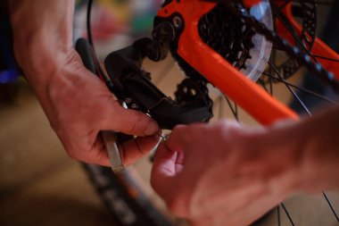 Direksiyonun yanında çok aletli ve frenleri olan bir adamın eli. Bisiklet tamiri, disk frenleri, hız anahtarı, yol onarım seti, sürüş için hazırlık..