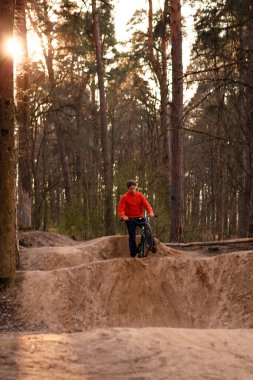 Kaluga, Rusya-9 Nisan 2020. Ormandaki bisikletçiler, dağ bisikleti sporu için slaytlarla bir pistte. Dağ bisikleti atlama, ekstrem sporlar.