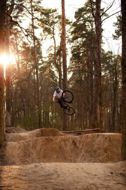 Kaluga, Rusya-9 Nisan 2020. Ormandaki bisikletçiler, dağ bisikleti sporu için slaytlarla bir pistte. Dağ bisikleti atlama, ekstrem sporlar.