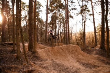 Kaluga, Rusya-9 Nisan 2020. Ormandaki bisikletçiler, dağ bisikleti sporu için slaytlarla bir pistte. Dağ bisikleti atlama, ekstrem sporlar.