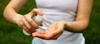 Bir kadın ellerine antiseptik sıkar - sağlığını, temizliğini, tehlikeli bakteri ve virüslerden korur. Koronavirüs salgını sırasında hijyen. Güzellik bakımı kavramı