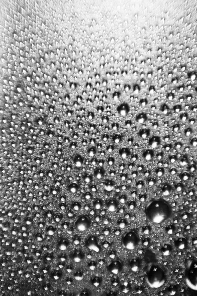 Parlak gümüş bir arka planda bulanık bir su damlasının dokusu. Bokeh ile makro damlalarının arkaplanı