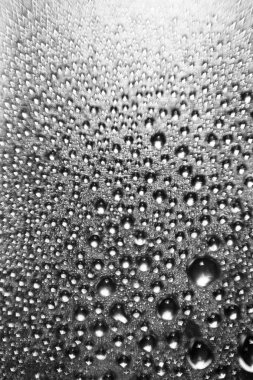 Parlak gümüş bir arka planda bulanık bir su damlasının dokusu. Bokeh ile makro damlalarının arkaplanı