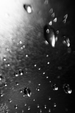 Parlak gümüş bir arka planda bulanık bir su damlasının dokusu. Bokeh ile makro damlalarının arkaplanı